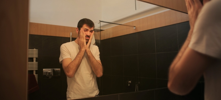 A distressed man looking in the mirror
