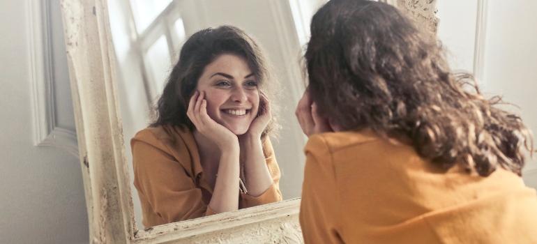 A woman smiling while looking in the mirror