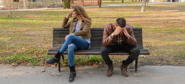 A nervous man and a woman sitting on a bench 