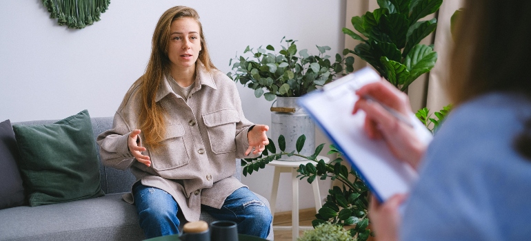 A woman talking to a therapist about how to support your sibling dealing with addiction