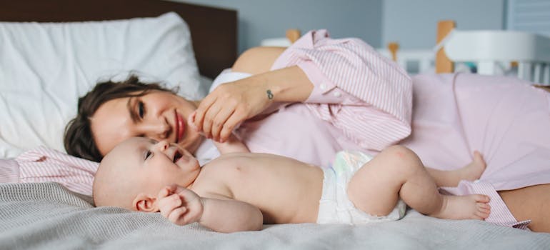 Woman playing with her baby in bed.