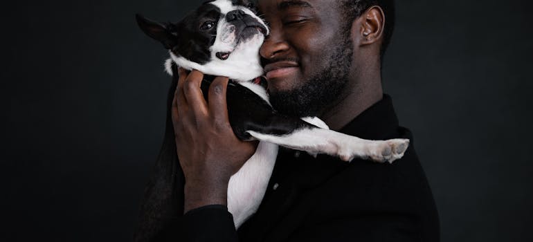 Man holding his French bulldog close to his face.