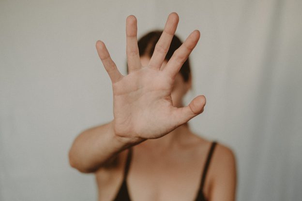 The girl hold her hand in front of her face