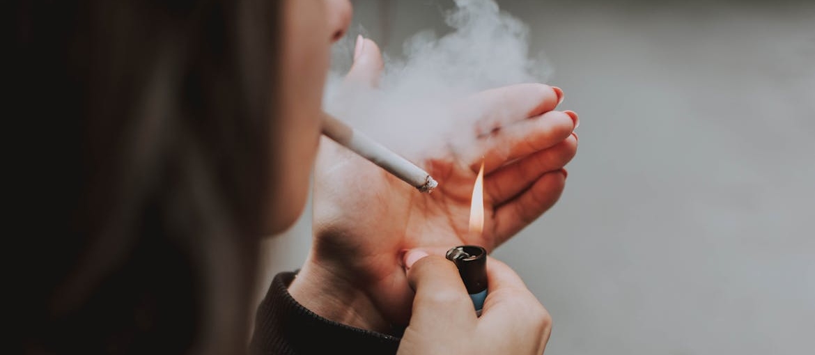 Woman lighting a cigarette.