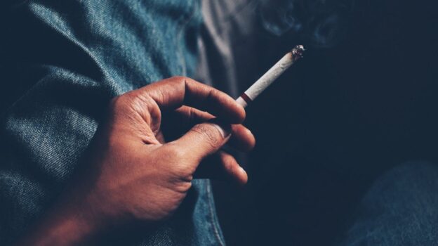 Person holding a cigarette.