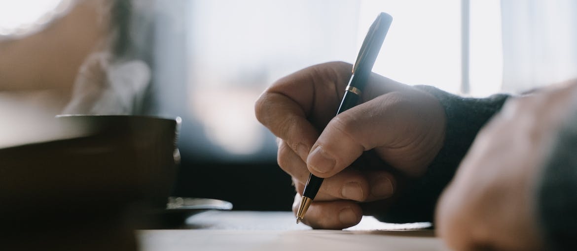 Person writing about who started AA on a piece of paper.