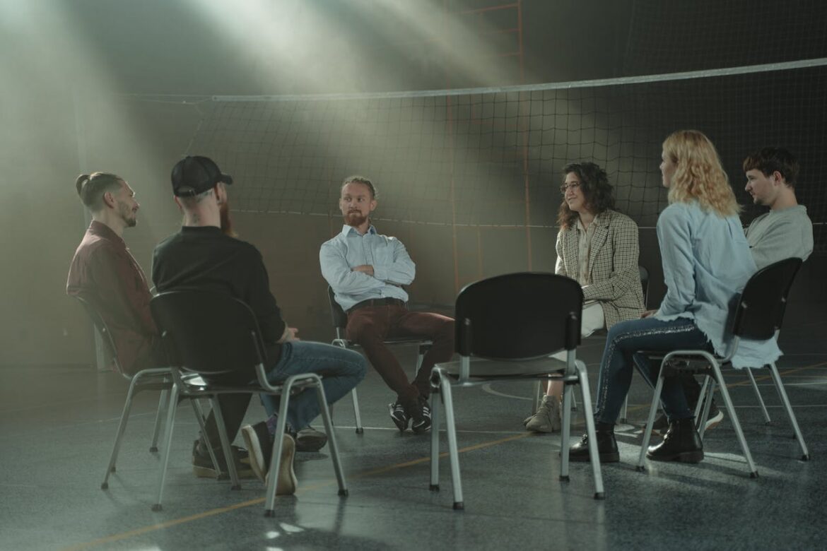 People sitting in a circle and talking about who started AA and how it helped them.