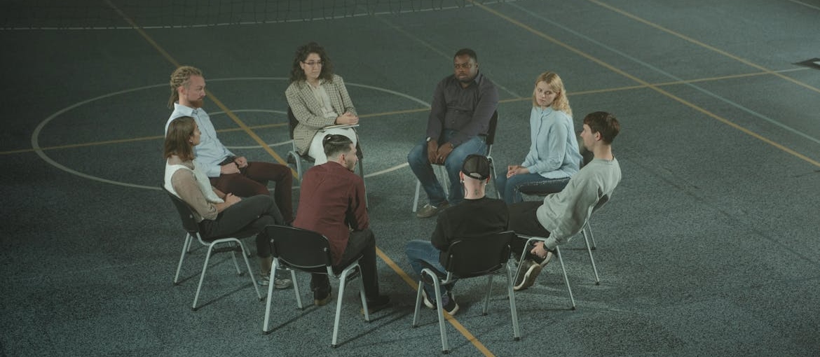 People sitting in a circle and talking about who started AA and how it helped them.