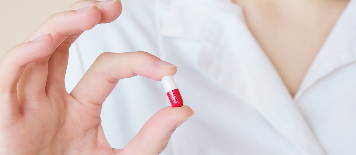 Woman holding a pill.