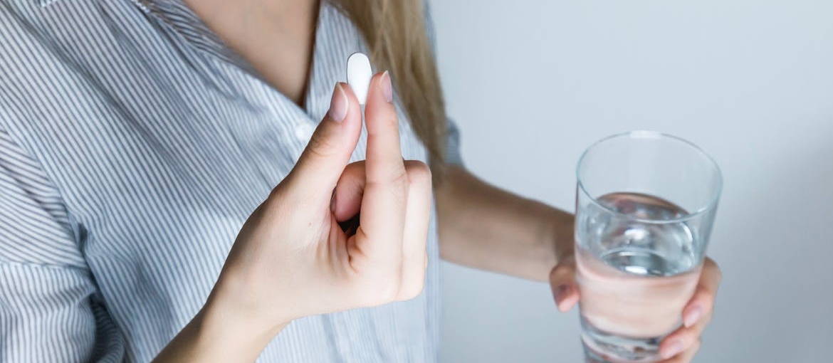 Woman taking a pill after learning how do mood stabilizers work.