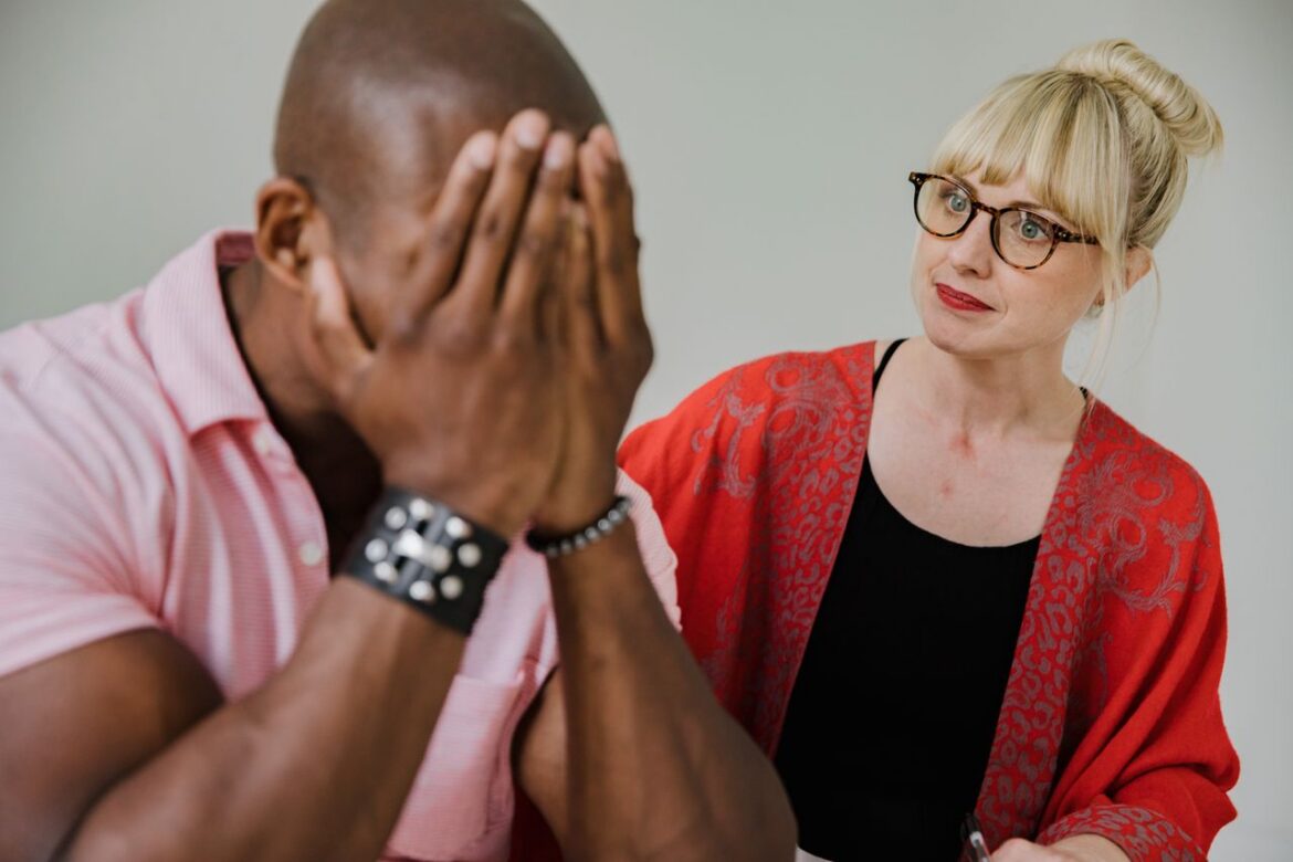 Two adults having a supportive private conversation about the signs someone is drinking too much.