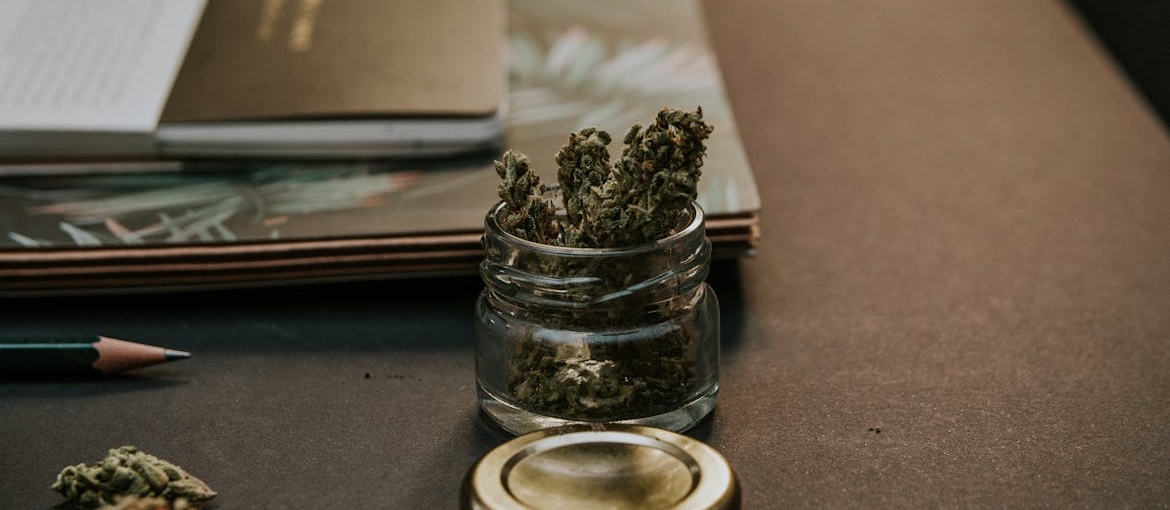 Marijuana in a jar on a table.