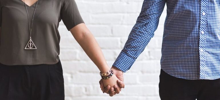 A close-up of a couple holding hands.