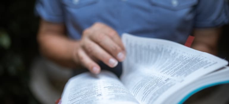 A close-up of a person in a blue shirt reading.