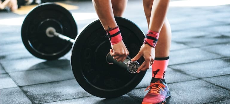 Person adjusting weights on exercise equipment.