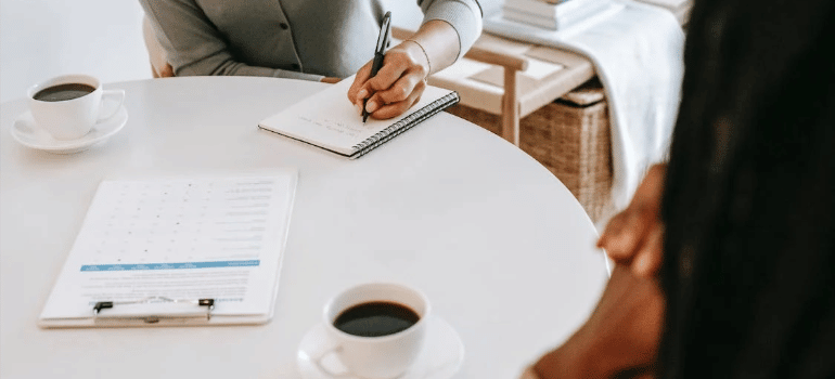 A close-up of a therapist keeping notes during an individual therapy session.