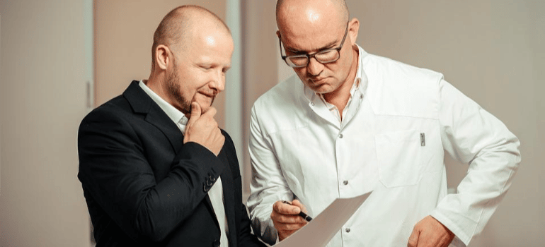 A patient and a doctor reviewing a medical document.
