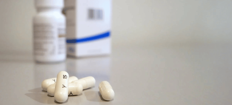 Five oblong medication pills on a flat surface.
