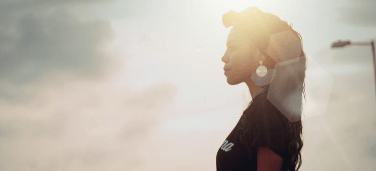 A woman looking defiantly in the distance under the sunshine.
