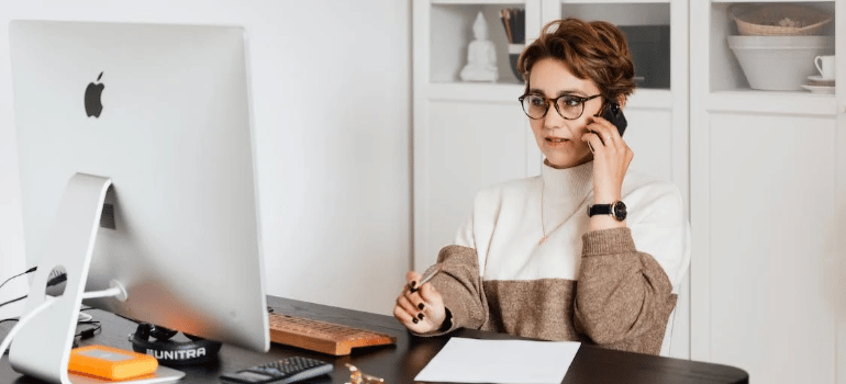 A woman in her office talking on the phone.