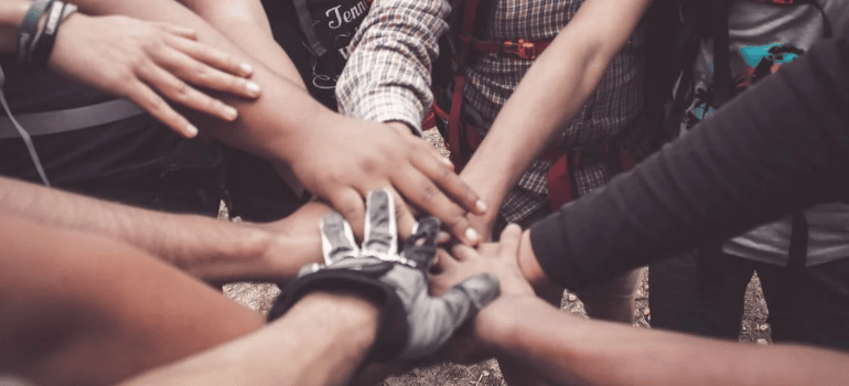 A close-up of a group of people joining hands.