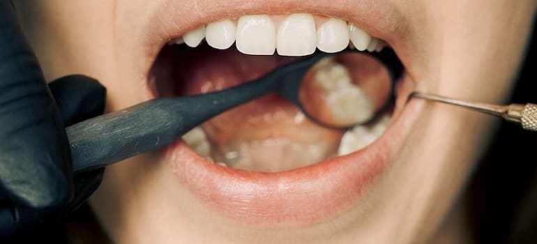 A close-up of a person’s open mouth at the dentist.