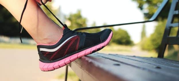 Person putting on their shoes and preparing to experience the benefits of physical activity in recovery from alcohol or drug addiction