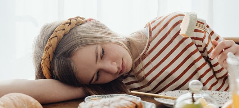 A depressed girl lying on a wooden table.