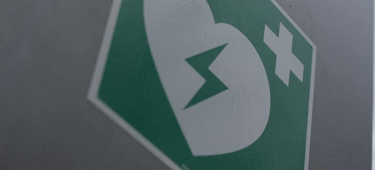 The defibrillator sign on the wall.