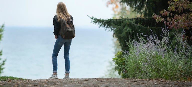 A woman with a backpack walking in nature.