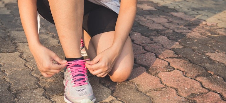 Person putting on their running shoes to exercise as a way to control anxiety during cocaine rehab in WV.