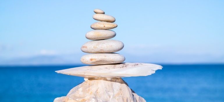 White pebbles stacked on top of a rock on the beach.