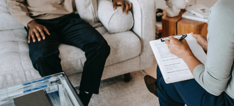 A close-up of a psychologist keeping notes during a therapy session.