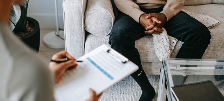 A close-up of a psychologist keeping notes during a therapy session.