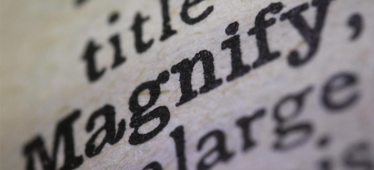 A close-up of a dictionary page which reads “magnify”.