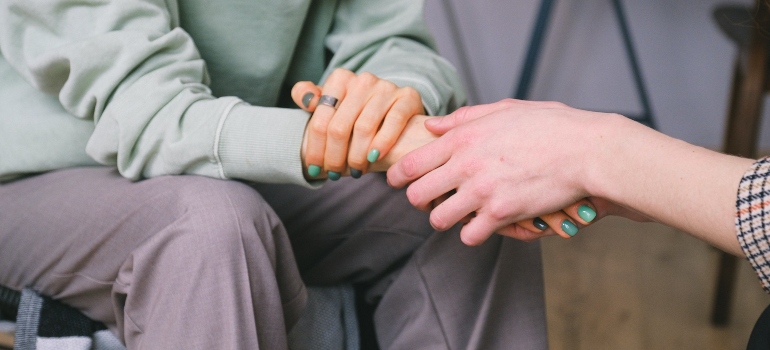 two people holding hands in support