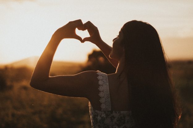 Woman making a finger heart.