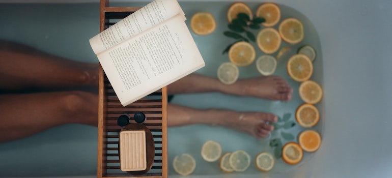 Person taking a bath and reading a book.