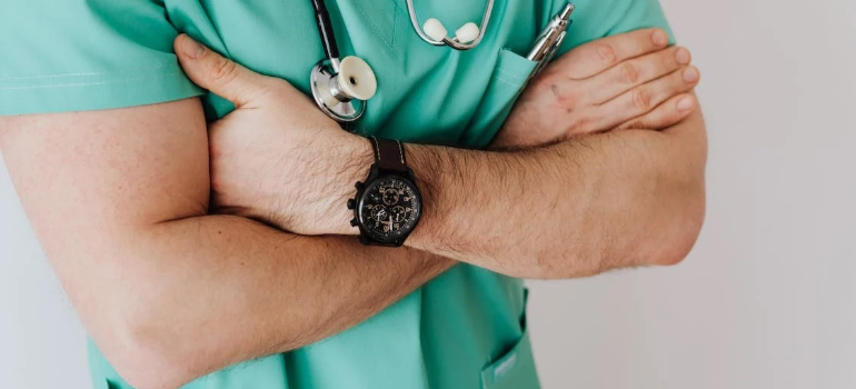 A close-up of a doctor’s crossed hands showing are some professions more prone to addiction than others