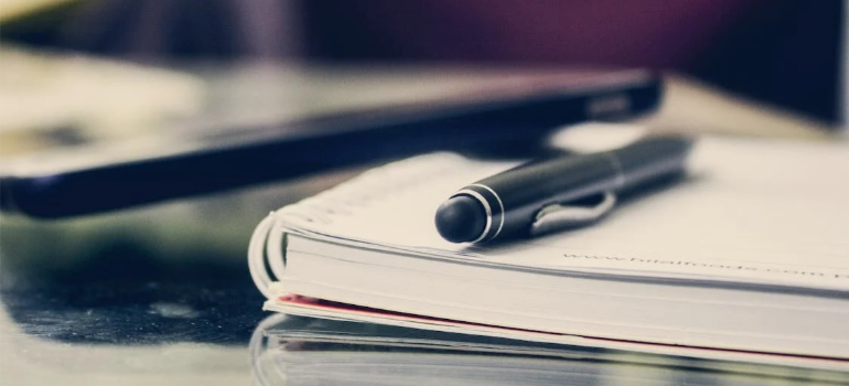 A close-up of a black pen on a notebook.