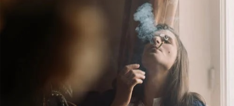 A close-up of a woman smoking indoors.