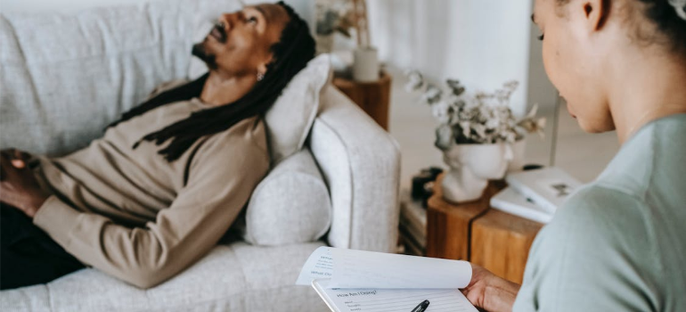 A psychotherapist and a patient lying on the couch during a therapy session.