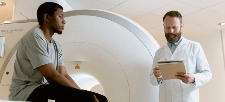 A doctor and a patient discussing as the doctor looks through the patient’s records.