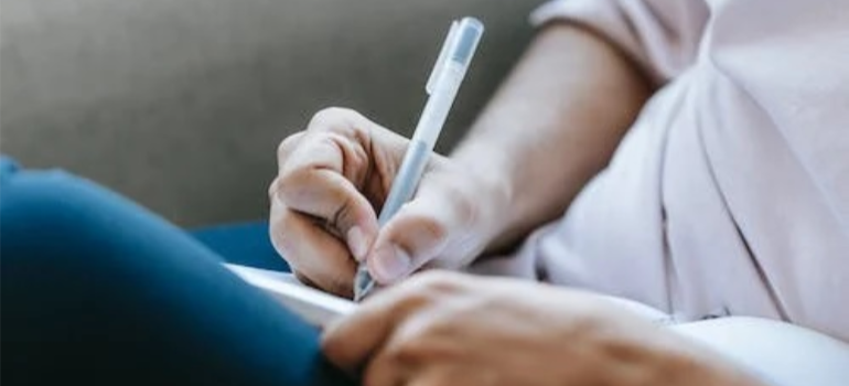 A close-up of a person keeping notes with a pen.