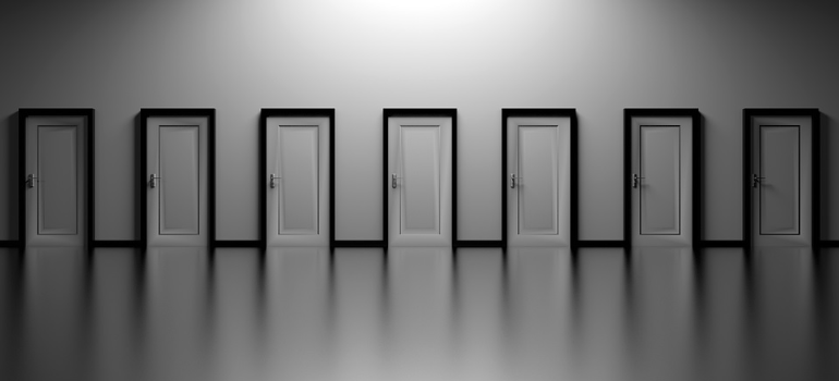 A series of white doors on a white wall.
