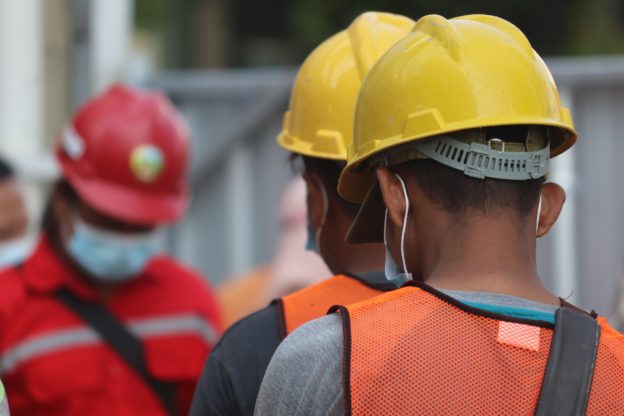 Men in a construction worker outfits as a featured image for the article are some professions more prone to addiction than others