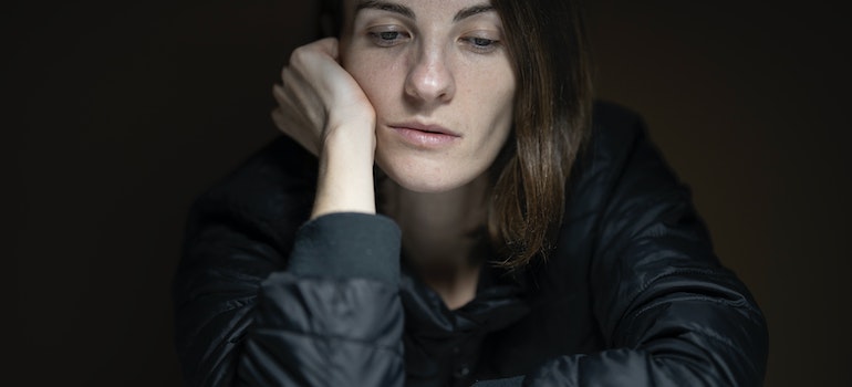 A sad woman wearing black clothes deep in thought about a rehab center near Buckhannon WV