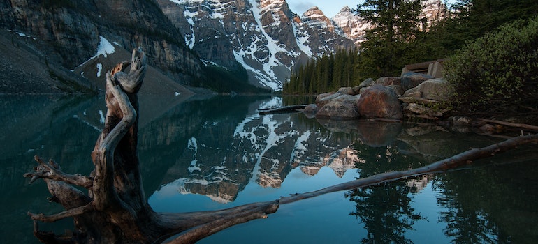 Lake in a forest with mountains in the background.