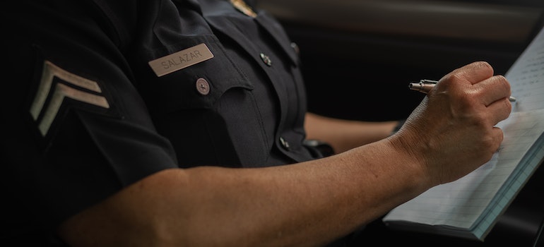 Police woman writing on a notepad.