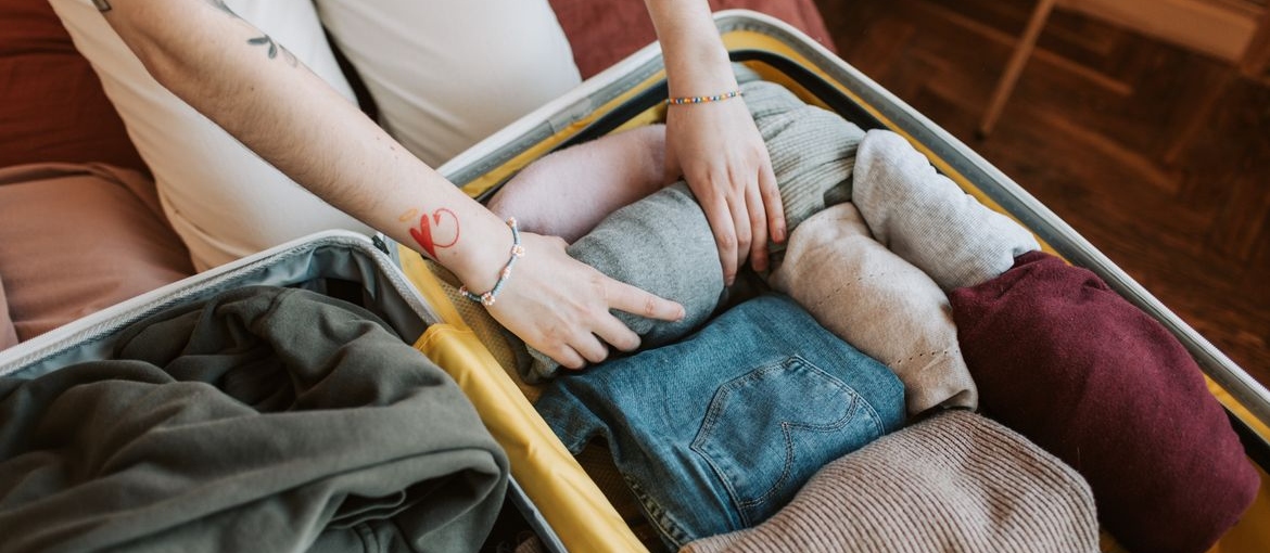 Woman packing clothes into a suitcase.